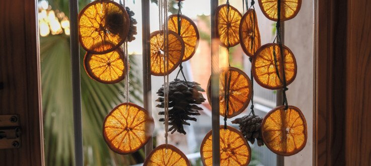 Activité de Noël : guirlandes de pommes de pin et tranches d’orange séchées